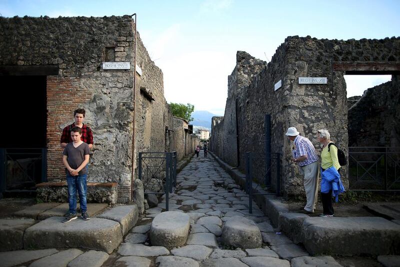 Tourists look down an ancient Roman cobbled street at the Unesco World Heritage site of Pompeii. Alessandro Bianchi / Reuters