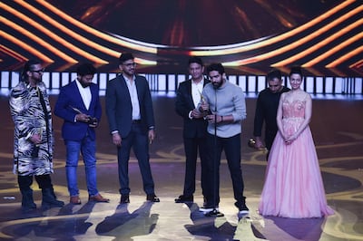 (L-R) Bollywood music directors Honey Singh, Saurabh, Vaibhav, Bhushan Kumar, Amaal Mallik, Rochak Kohli and Divya Khosla Kumar receive the Best Music Direction award for movie 'Sonu Ke Titu Ki Sweety' during the 20th International Indian Film Academy (IIFA) Awards at NSCI Dome in Mumbai on September 18, 2019. / AFP / INDRANIL MUKHERJEE        
