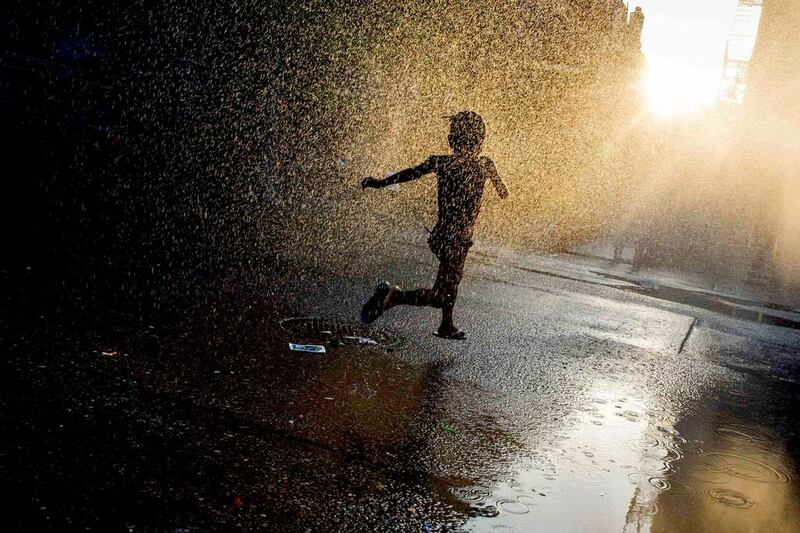 A girl runs through a sprinkler at a playground in the Brooklyn borough of New York July 7, 2014. Reuters