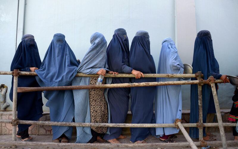 Afghan burqa-clad women stand as they wait to receive food donated by a private charity during Ramadan, in Mazar-i-Sharif. Farshad Usyan / AFP