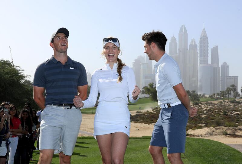 Niall Horan, right, with Rory McIlroy, left, and Paige Spiranac on the eighth tee during the pro-am at Emirates Golf Club. David Cannon / Getty Images