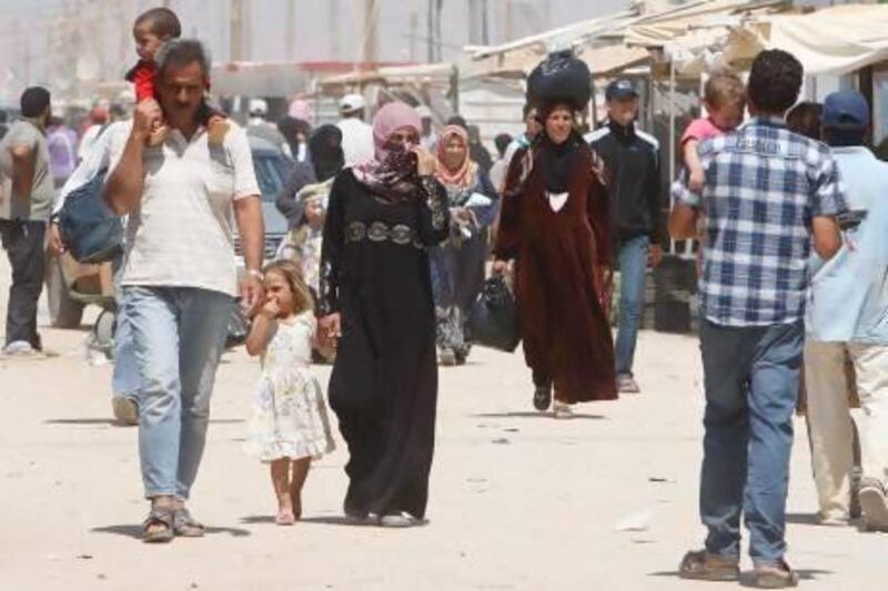 Syrian refugees walk the main street at Zattari refugee camp, at Mafraq city, Jordan. The UN says more than two million have fled their country.