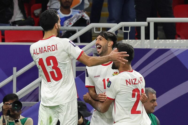 Jordan's Yazan Al Naimat celebrates with teammates after scoring their opening goal. AFP