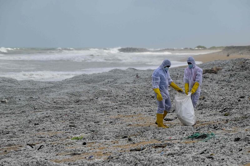 Sri Lankan soldiers remove debris from the 'MV X-Press Pearl' that washed ashore on a beach in Colombo. AFP