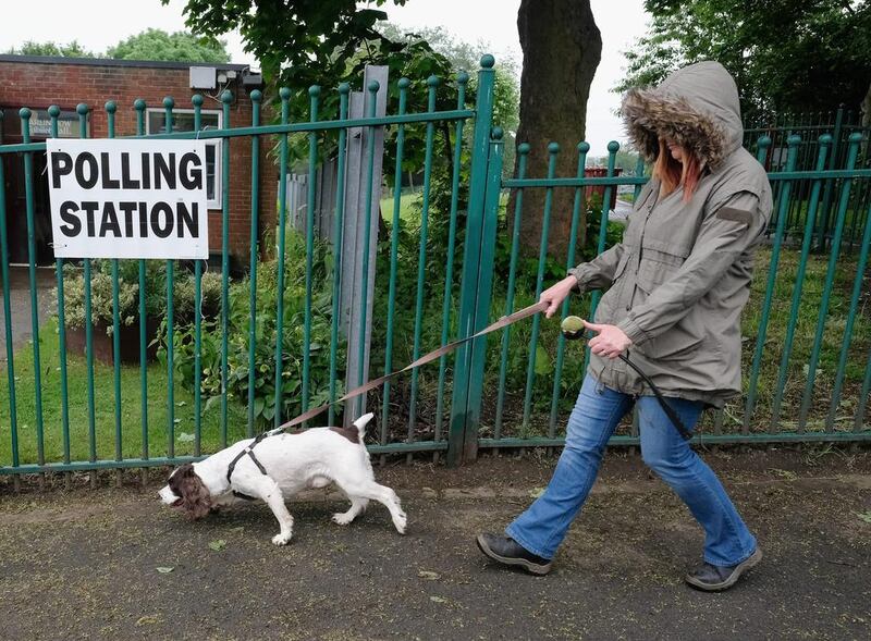 woman walks her dog past a polling station in Carlin How, North Yorkshire, northern England. United Kingdom. Getty Images