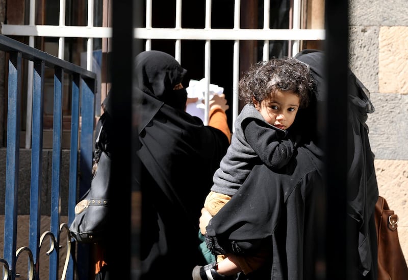 Women and a boy wait for foodstuff assistance vouchers at an aid distribution center in Sanaa, Yemen January 25, 2021. Picture taken January 25, 2021. REUTERS/Khaled Abdullah