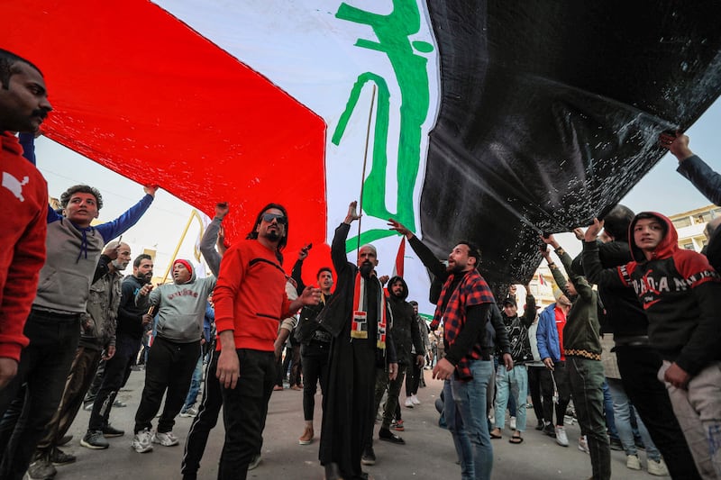 Protesters wave an Iraqi flag during a protest against the depreciation of the dinar against the US dollar outside the Central Bank of Iraq in Baghdad. AFP