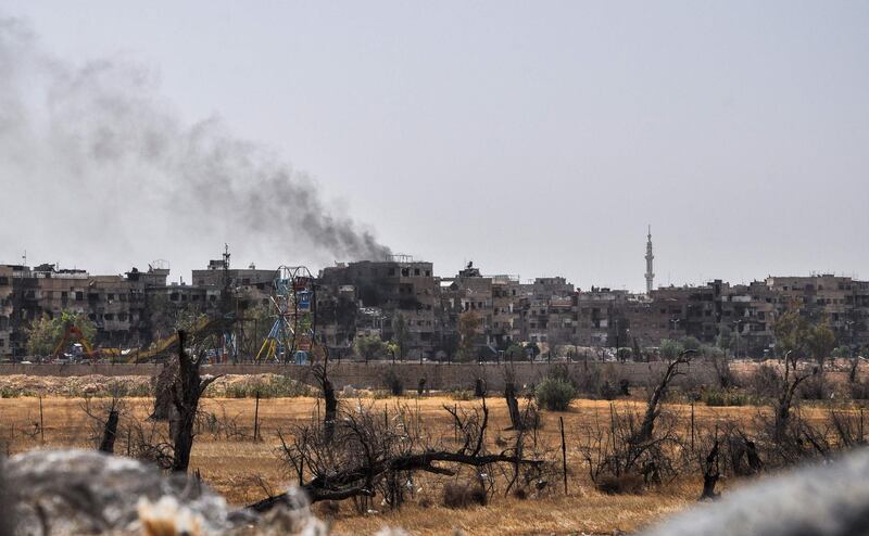 A picture taken during a Syrian army-organised tour on April 20, 2018 shows a view of the Eastern Ghouta town of Douma on the outskirts of the capital Damascus, with a smoke plume rising in the background. / AFP PHOTO / STRINGER