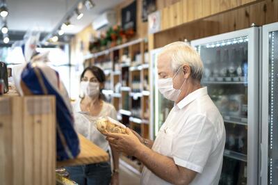 Senior couple buying with face mask at store