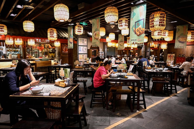 People dining at a restaurant in Beijing after the government eased some Covid-19 restrictions.  AFP