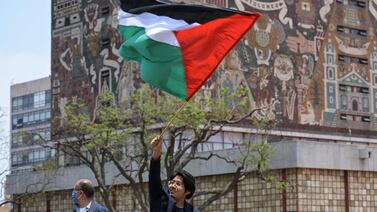 An activist waves a Palestinian flag at the Autonomous University of Mexico in Mexico City during a pro-Palestine protest. AFP