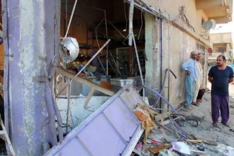 Residents inspect the site of a car bomb attack in the Shuala district in Baghdad.