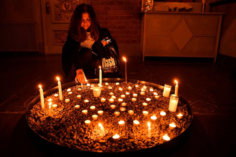 A mourner lights a candle at a memorial service for the victims of Ukrainian Airlines flight PS752 crash in Iran at Storkyrkan church in Stockholm.  AFP