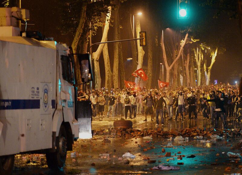 Turkish protesters confront riot police near the former Ottoman palace, Dolmabahce, where Turkey's Prime Minister Recep Tayyip Erdogan maintains an office in Istanbul, Turkey, late Saturday, June 1, 2013. Turkish police retreated from a main Istanbul square Saturday, removing barricades and allowing in thousands of protesters in a move to calm tensions after furious anti-government protests turned the city center into a battlefield. A second day of national protests over a  violent police raid of an anti-development sit-in in Taksim square has revealed the depths of anger against Prime Minister Recep Tayyip Erdogan, who many Turks view as increasingly authoritarian and dismissive of opposing views.(AP Photo)