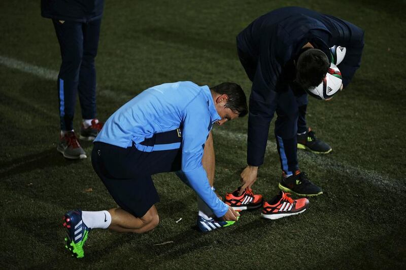 Fernando Torres puts on his boots during his training session with Atletico Madrid on Tuesday. Susana Vera / Reuters