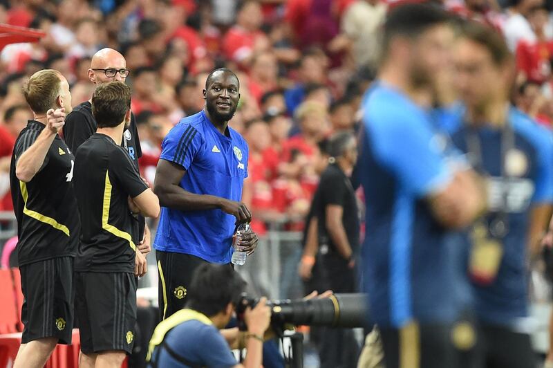 Romelu Lukaku watches on from the sidelines as Manchester United play a pre-season friendly in Singapore. AFP