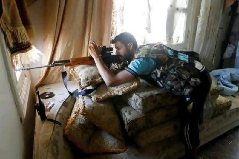 A Free Syrian Army sniper looks through the sights on his rifle inside a house in Aleppo. The fighters have been described as effective as 'they've learnt to cooperate, and they've learnt from their mistakes'.
