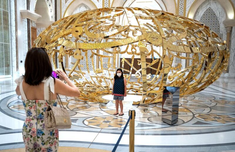 Abu Dhabi, United Arab Emirates, October  20, 2020.   Visitors take a photo in front of  the work of art by Mattar Bin Lahej entitled, The Power of Words, which is inspired by a quote from the late Sheikh Zayed bin Sultan Al Nahyan:
"Wealth is not money and oil.  Wealth lies in people, and is worthless if not dedicated to serve the people."
Victor Besa/The National
Section:  NA
Reporter: