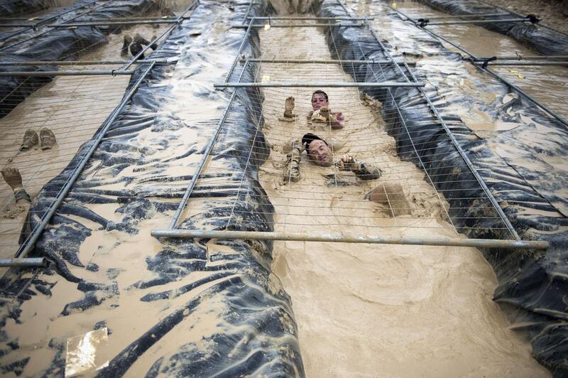 Runners take part in 'The Mud Day challenge', a 13-kilometre obstacles course, on in Beynes near Paris, on Saturday. Martin Bureau / AFP