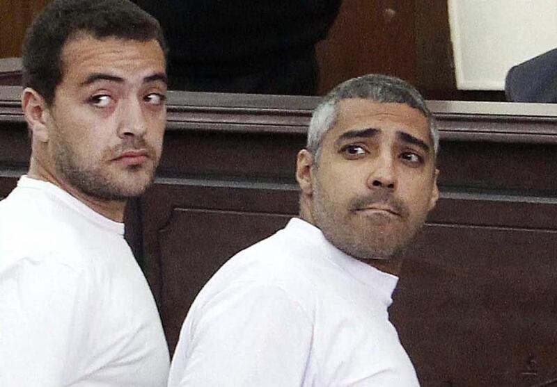 FILE — In this Monday, March 31, 2014 file photo, Al-Jazeera English producer Baher Mohamed, left, Canadian-Egyptian acting Cairo bureau chief Mohammed Fahmy, right, appear in court along with several other defendants during their trial on terror charges, in Cairo. Egypt court orders release on bail of Al-Jazeera English journalists. (AP Photo/Heba Elkholy, El Shorouk, File) EGYPT OUT