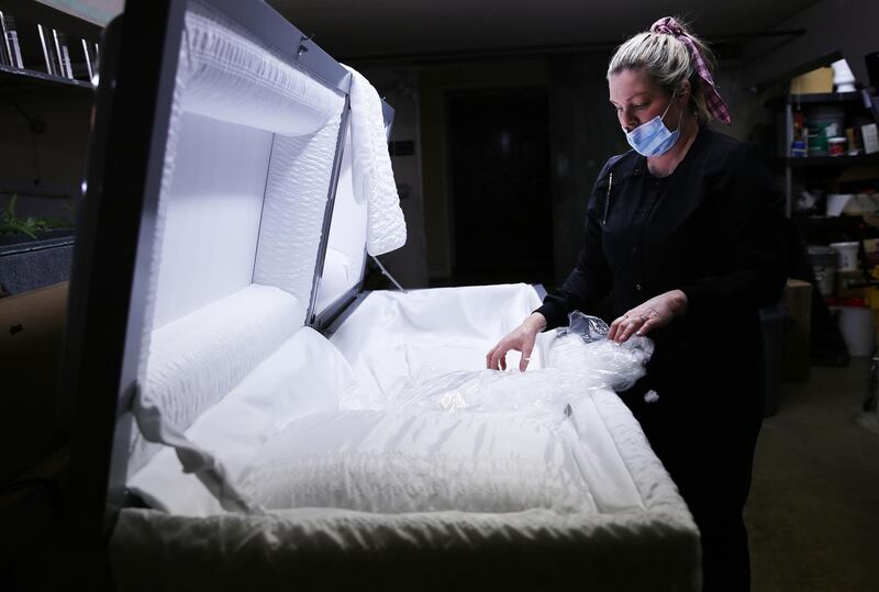 EL CAJON, CALIFORNIA - JANUARY 15: (EDITORIAL USE ONLY) Embalmer and funeral director Kristy Oliver unwraps a new casket which will be used for a person who died after contracting COVID-19 at East County Mortuary on January 15, 2020 in El Cajon, California. The mortuary on average was handling about 50 bodies per month but owner Robert Zakar believes they may process closer to 100 in January as California continues to see a spike in coronavirus deaths. The mortuary holds the bodies of those who pass away due to COVID-19 for a minimum of three days before they are processed along with various other COVID-related safety measures.   Mario Tama/Getty Images/AFP
== FOR NEWSPAPERS, INTERNET, TELCOS & TELEVISION USE ONLY ==
