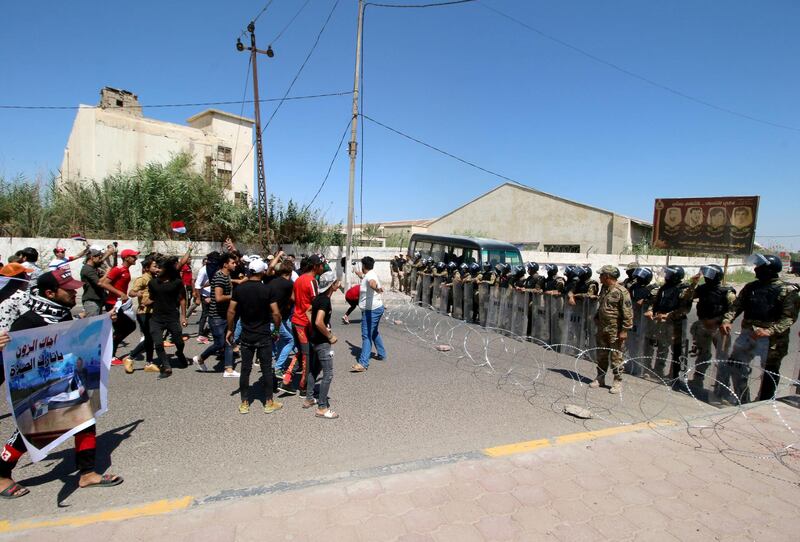 Iraqi security forces block the road in front of the demonstrators during an anti-government protest in front of the Governorate building in Basra, Iraq. Reuters
