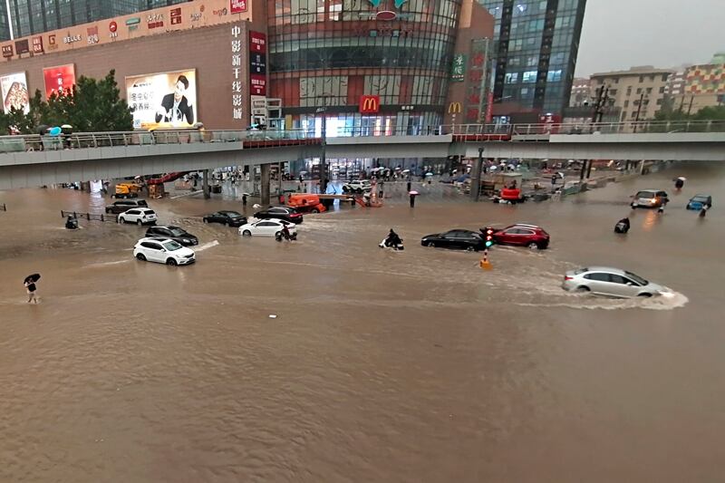 Vehicles are stranded after heavy rain in Zhengzhou, the capital city of China's central Henan province. Weather bureaus said 200mm of rain fell on Zhengzhou in an hour on Tuesday.