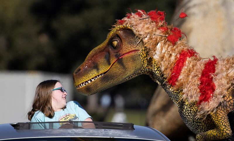 Hudson Mahaffay reacts to a staff member dressed like a raptor at the Jurassic Quest drive-thru Experience outside The Rose Bowl Stadium in Pasadena, California. Reuters