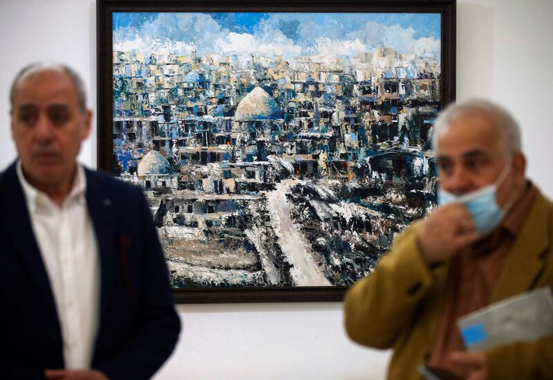 People visit a painting exhibition for contemporary Iraqi artists organised yearly by the Iraqi Plastic Artist Society in the capital Baghdad, on January 15, 2022.  (Photo by AHMAD AL-RUBAYE  /  AFP)