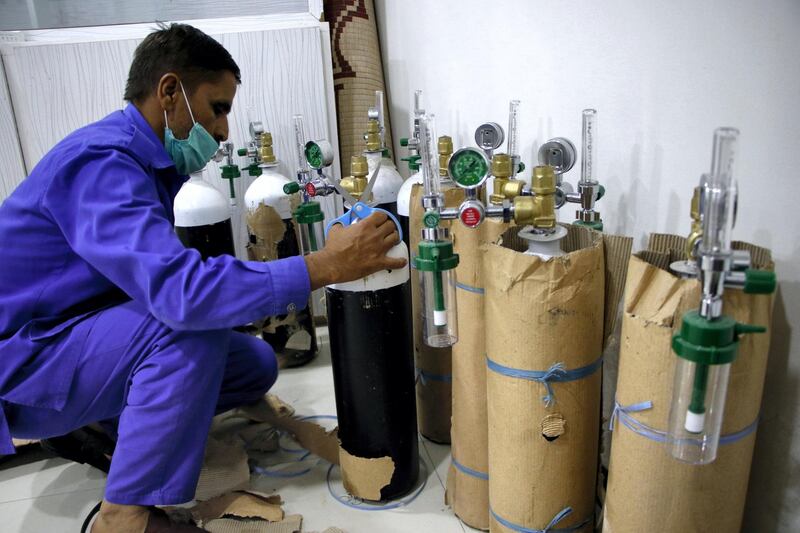 Khalid Hussain, 45 and an aid worker of Alkhidmat Foundation, is examining the oxygen cylinders before their delivery to COVID-19 patients. Imran Mukhtar/ The National