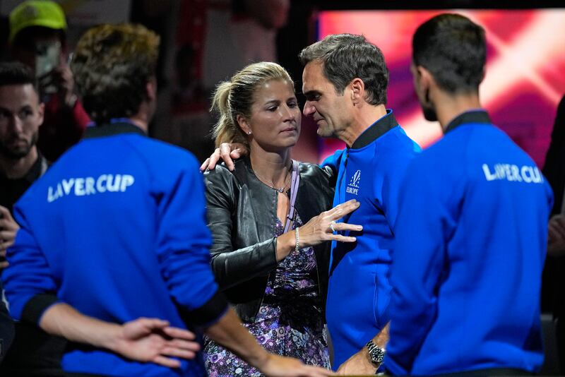 An emotional Roger Federer is embraced by his wife Mirka. AP