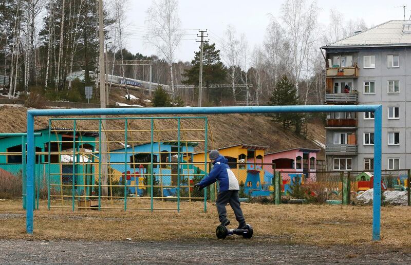 A boy rides a scooter near a goalpost on a football pitch in the Siberian town of Divnogorsk, Russia. Ilya Naymushin / Reuters