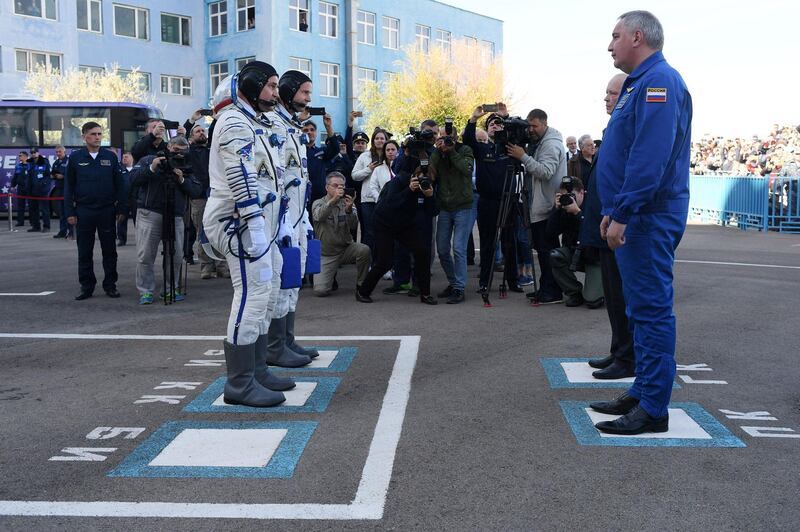 Nick Hague and Alexey Ovchinin report to Roscosmos head Dmitry Rogozin before boarding the Soyuz spacecraft. AFP