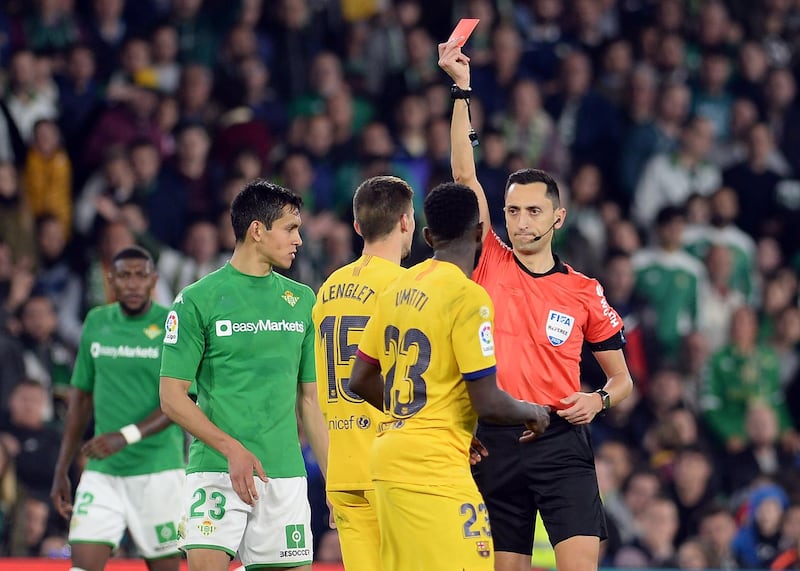 Referee Sanchez Martinez hands a red card to Barcelona's Clement Lenglet. AFP