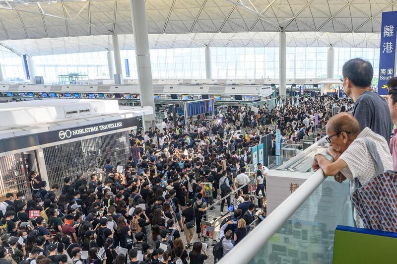 Hong Kong pro-democracy protesters (C) crowd the area in front of the departure gates to block access during another demonstration at Hong Kong's international airport on August 13, 2019.  AFP