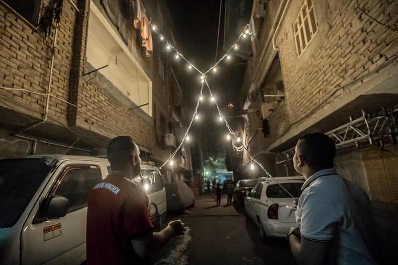 Egyptian youths decorate their residential street in preparation for the Muslim holy month of Ramadan in Cairo's Hadayek el-Maadi district, on April 21, 2020. - From cancelled iftar feasts to suspended mosque prayers, Muslims across the Middle East are bracing for a bleak month of Ramadan fasting as the threat of the COVID-19 pandemic lingers. Ramadan is a period for both self-reflection and socialising. Believers fast from dawn to dusk and then gather around a family or community meal each evening of Islam's holiest month, which begins later this week and ends with Eid al-Fitr festivities (Photo by Khaled DESOUKI / AFP)