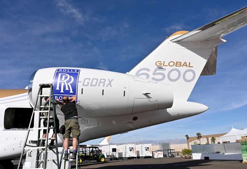 Workers apply a Rolls Royce decal to the engine of a Bombardier Global 6500 business jet. Rolls-Royce was hammered by the collapse in air travel during the Covid-19 pandemic. Reuters
