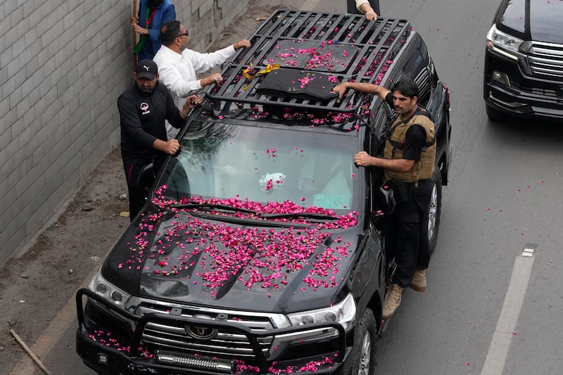 Security guards on the vehicle carrying former Pakistan prime minister Imran Khan from Lahore to Islamabad.  AP