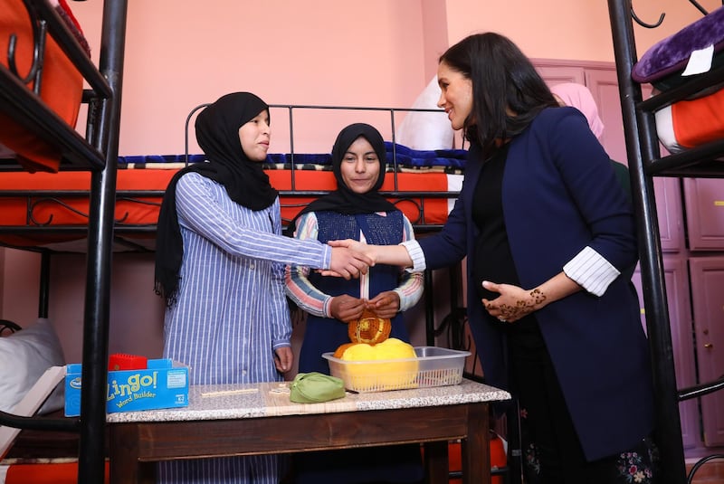 Meghan, Duchess of Sussex speaks to young girls as she visits the Education For All boarding house. Getty Images