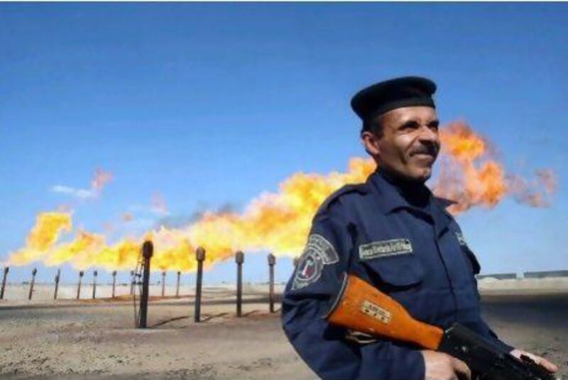 An officer guards a section of the Barjisiya oil fields near Basra. The field's gas is currently flared off. AFP PHOTO / ESSAM AL-SUDANI