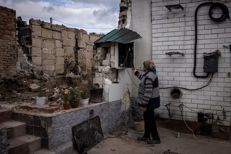 A woman outside her home, which was destroyed during battles at the start of the conflict, in Yahidne, Chernihiv. Getty Images