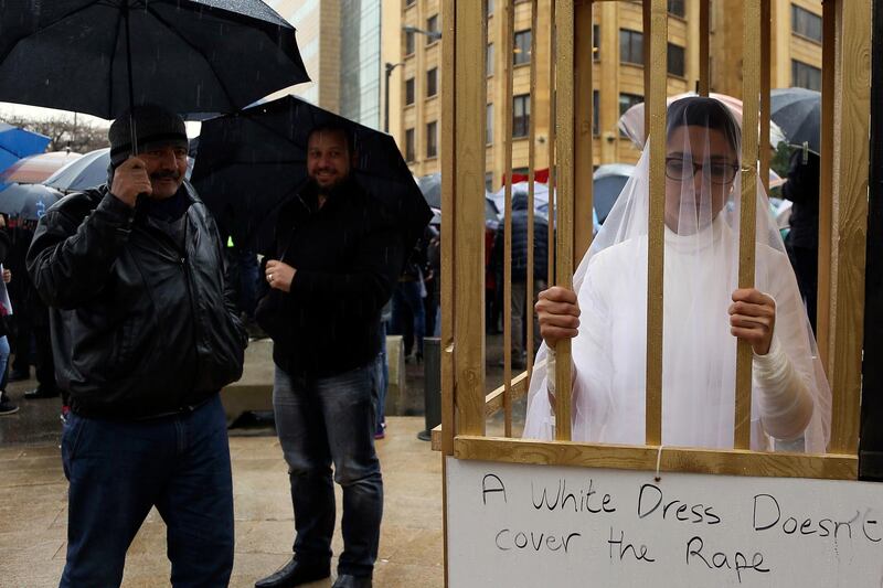 FILE -- In this March 15, 2017 file photo, an activist from the Lebanese NGO Abaad stands in a golden cage dressed as a bride while during a protest in front of the government building in downtown Beirut, Lebanon. On Wednesday Aug. 16, 2017, Parliament repealed a law that allowed rapists to avoid prison by marrying their victims, which had been in place since the 1940s, and follows years of campaigning by women's rights advocates. Tunisia, Morocco and Egypt have canceled similar "marry the rapist" clauses over the years, and Jordan's parliament recently repealed a similar law. (AP Photo/Hassan Ammar, File)
