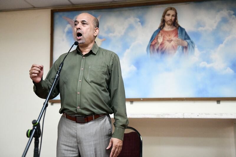 Walter Braganza, head of choir, leading a practice session.