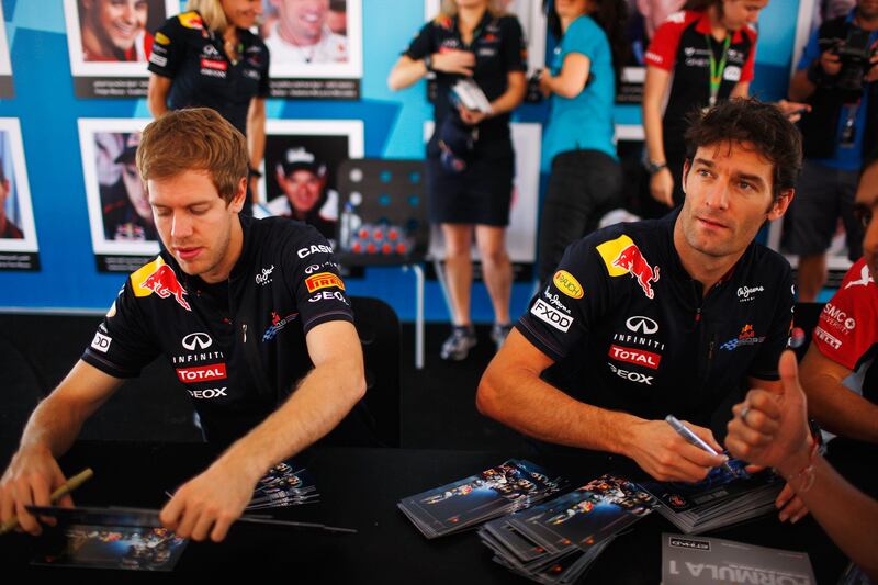 ABU DHABI, UNITED ARAB EMIRATES - NOVEMBER 11:  Sebastian Vettel of Germany and Red Bull Racing and Mark Webber of Australia and Red Bull Racing sign autographs for fans before practice for the Abu Dhabi Formula One Grand Prix at the Yas Marina Circuit on November 11, 2011 in Abu Dhabi, United Arab Emirates.  (Photo by Mark Thompson/Getty Images) *** Local Caption ***  132202083.jpg