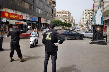 Hezbollah members block a road in southern Beirut as the Islamic Health Society, an arm of the Iran-backed militant group, sprays disinfectant as a precaution against the coronavirus. AP Photo