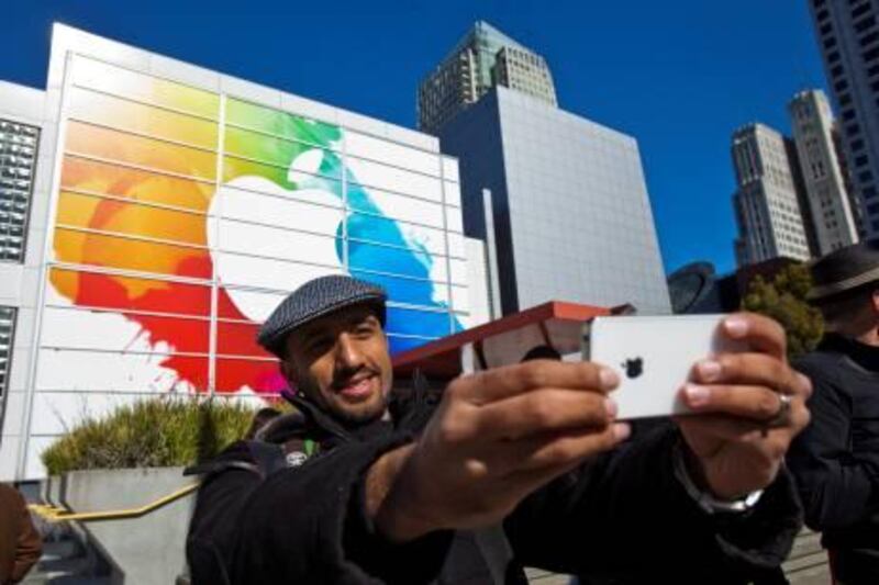 epa03135899 Apple enthusiast Mohammed Jawad from Dubai - United Arab Emirates, stopped to take a photo of him self and the Apple clad facade of the Yerba Buena Center, where Apple is holding a special event to introduce the newest iPad and other products in  San Francisco, California, USA 07 March 2012.  EPA/PETER DaSILVA *** Local Caption ***  03135899.jpg