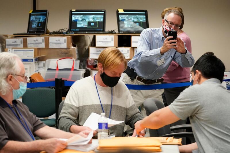 Republican canvas observer Ed White, takes photos with his smart phone as Lehigh County workers count ballots as vote counting continues in Allentown Pennsylvania. AP Photo