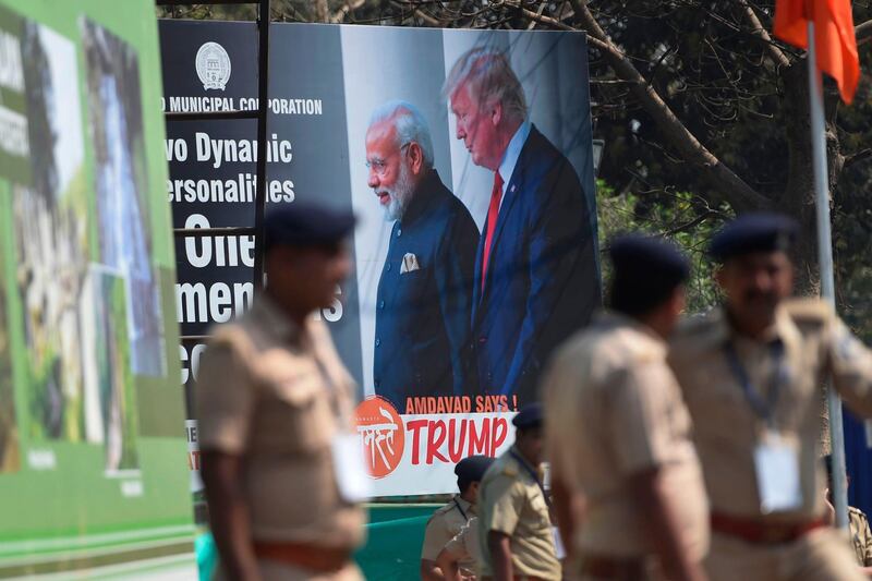 Policemen stand in front of a billboard displaying a picture of India's Prime Minister Narendra Modi and US President Donald Trump in Ahmedabad, ahead of Trump's arrival.   AFP