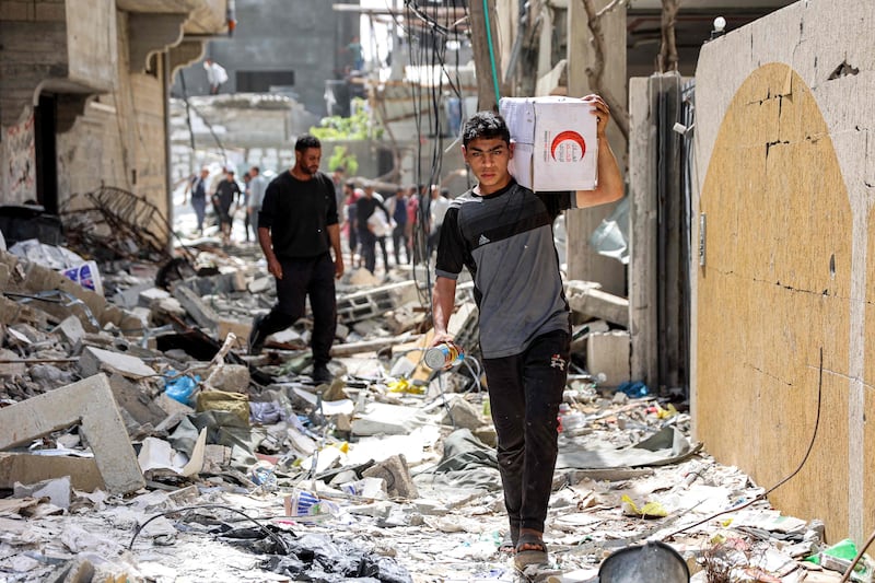 A youth carries a box of aid to his family