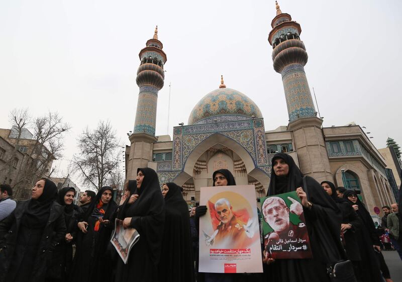 Iranian women hold a portrait of the newly-appointed head of the Islamic Revolutionary Guards Esmail Qaani (L) during an anti-US rally to protest the killings during a US air stike of Iranian military commander Qasem Soleimani (image L) and Iraqi paramilitary chief Abu Mahdi al-Muhandis, in the capital Tehran on January 4, 2020.  Soleimani, the 62-year-old deputy commander of the Revolutionary Guards, will be laid to rest next week in his hometown of Kerman as part of three days of ceremonies across the country, the Revolutionary Guards said. / AFP / ATTA KENARE
